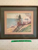 Full view of framed original watercolour coastal landscape painting showing trees, shoreline, and ocean body. Measurement tag reads 25" x 20".