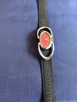 Close-up image of the vintage BIRKS sterling silver ladies wristwatch with a red oval dial and black mesh strap.