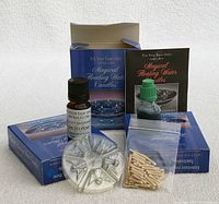 Three unopened unopened packs of Aromaglow Magical Floating Water Candles in red, blue, and green colors with included candle wicks and fragrance oils.