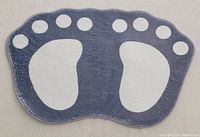 Top side of the bath mat showing the blue and gray footprint design with toes.
