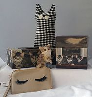 All five items displayed together including fabric cat doorstop, wristlet clutch, kitty statue, tissue box, and lidded box