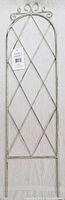 Full view of vintage style garden wall trellis with off-white distressed coloring, lattice design, and curling details at the top.