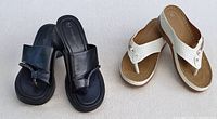 Two pairs of sandals side by side on a white background, black slip-on and off-white wedge flip-flops.
