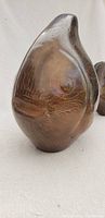 Side view of vintage pottery fish sculpture showing etched patterns and rounded form
