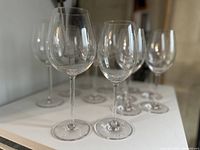 Group photo showing 12 clear acrylic stemmed wine glasses in two sizes for red and white wine.