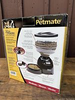 Photo of the original Petmate box with branding, product images, and description showing capacity and features of the automatic pet feeder.