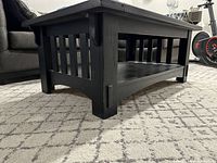 Side and angle view showing slatted side panel design and substantial wood construction with black stain.