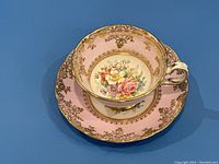 Top view of pink Grosvenor tea cup and saucer showing floral design and gold filigree on both pieces.