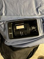 Close-up photo of the built-in black electric air pump embedded in the mattress material, showing control switch and warning label.