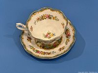 Top view of the tea cup and saucer showing floral detailed pattern and blue gold rim.
