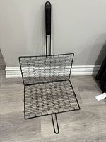 Wire grilling rack with folding panels and handle