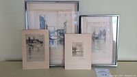 Four small original etchings grouped together; two framed and two unframed, showing detail and layout of the lot