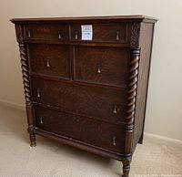 Front view of antique oak dresser showing six drawers, rope twist columns and brass handles