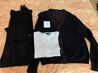 Four men's fashion items displayed on patterned cloth: black turtleneck sweaters, a two-tone cardigan, and grey short-sleeved shirt.