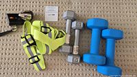 Full view of hand weights, reflective straps, and bike light on carpet