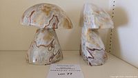 Front and side view of the two mushroom-shaped marble bookends showing color and veining.