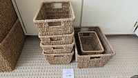 Stack of four mid-sized woven baskets next to the larger and smaller ones