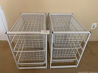 Front view of two white wire drawer units each featuring three sliding wire mesh drawers within a white wire frame.