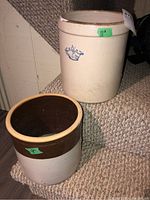 Two stoneware crocks; one beige with blue crown emblem, one two-tone brown and beige with glazed interior