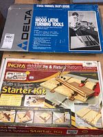 Box of Delta Model 46-730 Wood Lathe Turning Tools and Incra Build-It System Modular Jig Starter Kit.