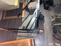 Photo of the metal ceiling mount bracket and frame for the punching bag system lying on the floor.