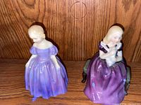 Front view of the two Royal Doulton figurines displayed side by side on a wooden surface.