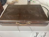 Wooden storage case closed, showing surface scratches and wear.