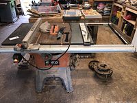 Front view of saw top, rip fence and accessories on table.