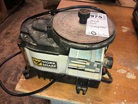 Angled overall view of bench-top sharpener on wooden surface