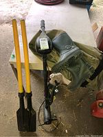 Photo of Minn Kota Endura C2 30 trolling motor, two boat oars, and hip waders on a table.