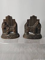 Front view of both bronze Scottie dog bookends showing dog figures and geometric bases.