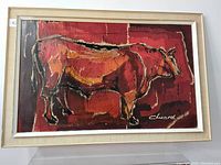 Frontal view of the bull painting showing colors, framing, and signature.