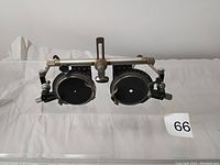 Front view of vintage optometrist trial frame glasses with attached black lens caps