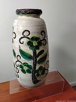 Front and side view of the large West German pottery vase showing the beige textured surface and raised floral relief design in brown and green.