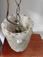 Close-up top view of the Lucite hanging lamp shade showing metal fixture and chain attachment points.