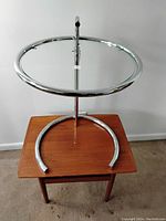 Full front view of chrome frame and glass top on wooden surface