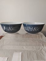 Front view of two blue and white Pyrex mixing bowls side by side displaying their exterior floral pattern.