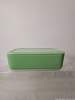 Side view of closed jadeite refrigerator container in light green.