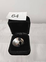 Top view of an abstract shaped sterling silver ring in a black velvet box