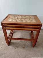 Stacked three teak side tables showing size progression and nesting configuration.