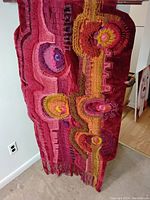 Full view of tapestry showing overall color palette, pattern and fringe