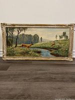 Full-frontal view of the framed print showing deer in a countryside scene near a stream.