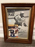 Framed black and white photo showing Darryl Sittler skating in Toronto Maple Leafs uniform with autograph and Pro Set hockey card inside frame.