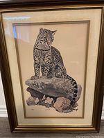 Full view of the framed print showing the ocelot and surrounding natural elements.
