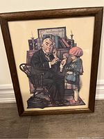 Front view of framed Norman Rockwell print showing the artwork of an older man and a young girl with a doll.