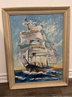 Full view of the framed oil on board painting depicting a clipper ship at sunset on the ocean with detailed clouds and waves.