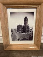 Front view of the framed black-and-white photo of the Old Hamilton City Hall, showing the building, street scene, and power lines, all within a natural wood frame.