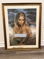 Front view of framed vintage print 'Girl of Valdarno' depicting blonde young woman with moody sky background. Print shows visible dirt or staining at lower margin inside frame.