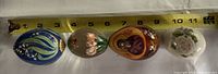 Set of four decorative eggs side by side with measuring tape showing about 9-11 cm in length each