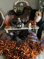 Full lot showing Halloween spider, owl, cat figurines, ledge sitting spooky figures, garland, and tombstone decoration